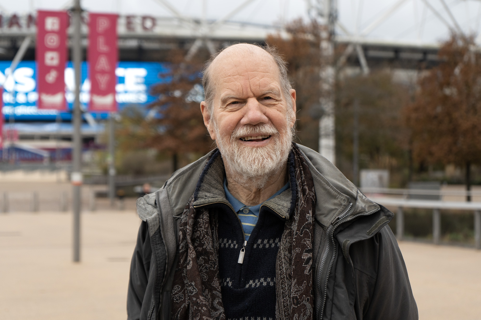 A man standing in front of a stadium.